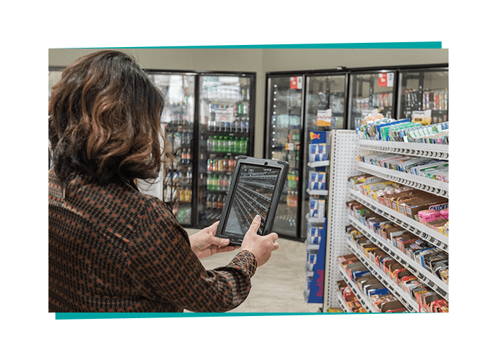 A c-store employee uses an iPad to capture a photo.